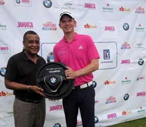 Diretor de Turismo da Jamaica Paul Pennicook entrega o troféu ao vencedor Jared Wolfe (à direita)